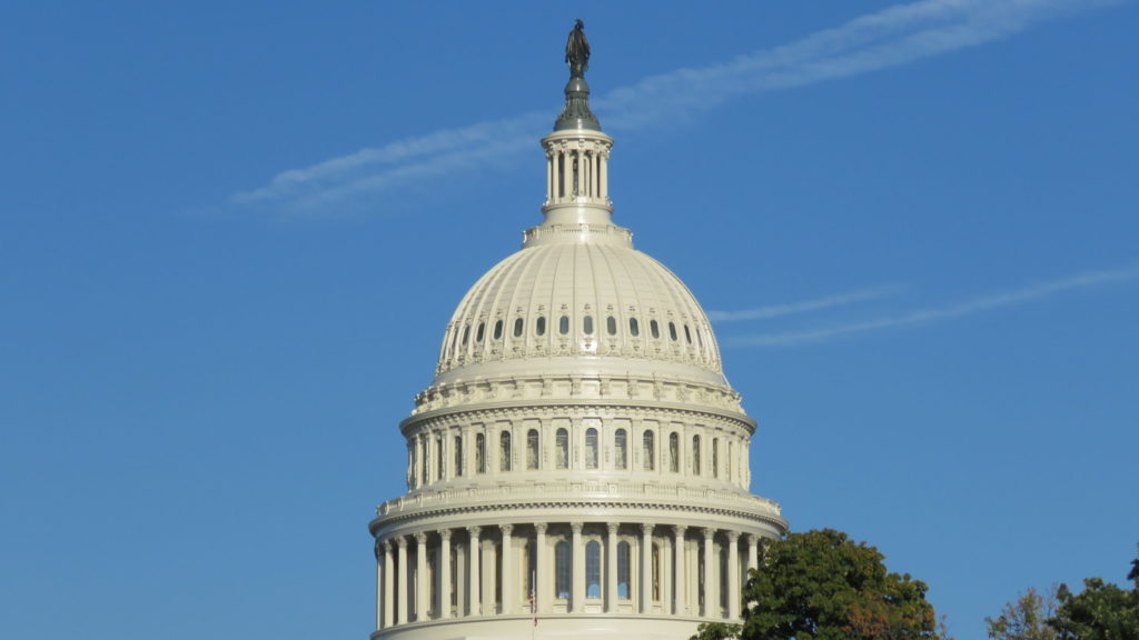 Image of the Dome of the US Capitol Building against a blue sky.